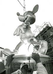 Mickey Mouse being hoisted onto the Crossroads tower at Walt Disney World in Orlando, Florida.